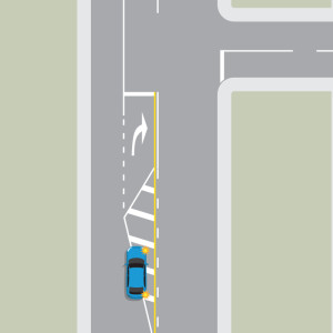 Blue car indicating turning right from a right turn bay with median strip.