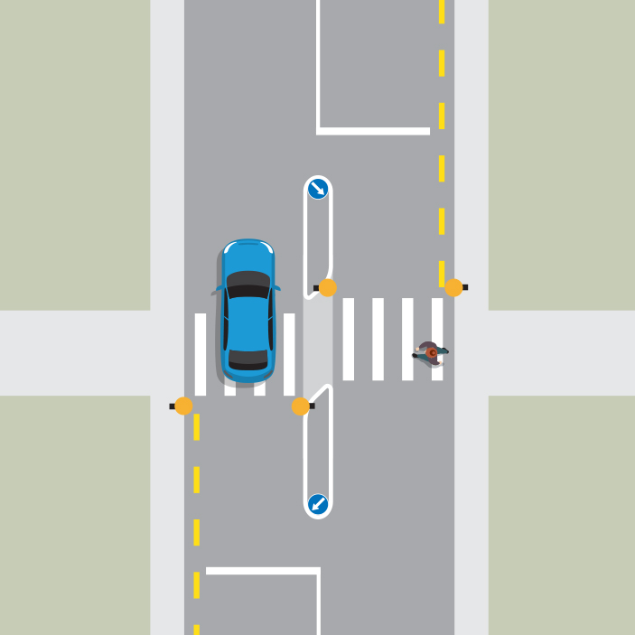 A blue car is driving northbound in the left lane while a pedestrian crosses at the pedestrian crossing in the right lane. There is a raised island in the middle of the pedestrian crossing.