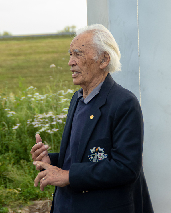Artist Fred Graham stands in front of the sculpture.